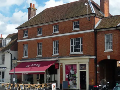The tall Georgian building on Odiham High Street that is home to El Castello, with a red awning