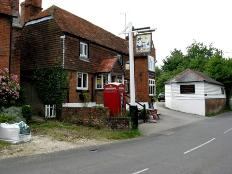 The Fox and Goose, an old brick and tile-hung pub in Greywell, with a red phone box outside