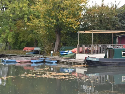 Rowing boats and hire boats moored at the Galleon Marine boatyard on the canal