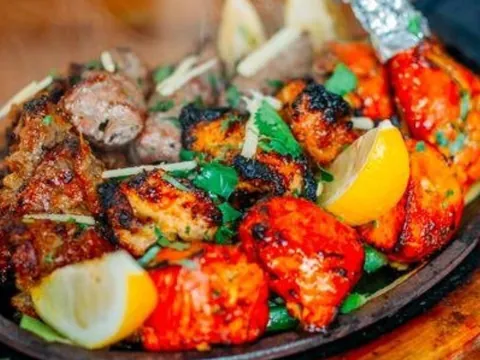 A sizzling tandoori mixed grill with lemon wedges
